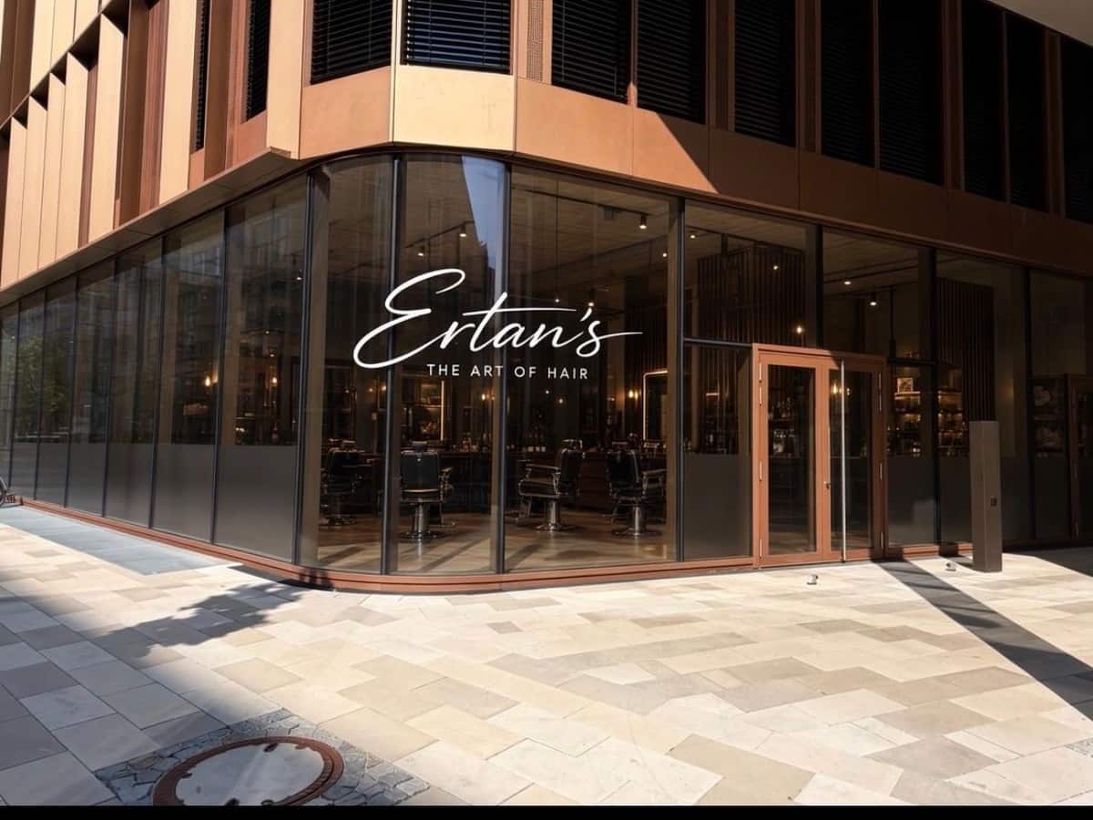 Ladenfront von Ertan's — The Art of Hair mit Schriftzug auf der Glasfassade